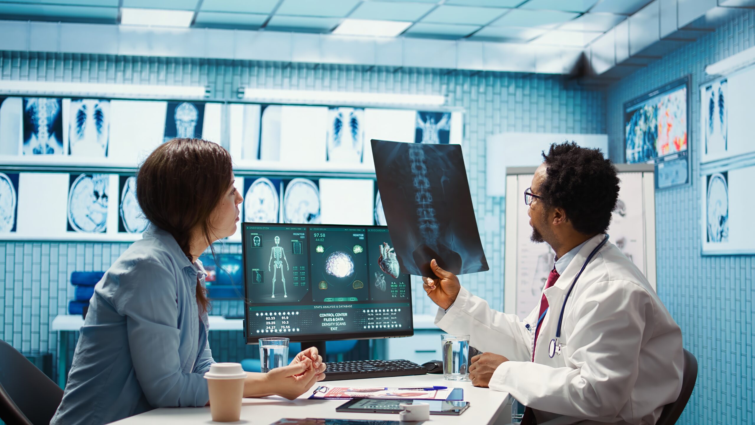 Doctor reviewing medical imaging scans and AI-assisted diagnostic data with a patient in a clinical setting.