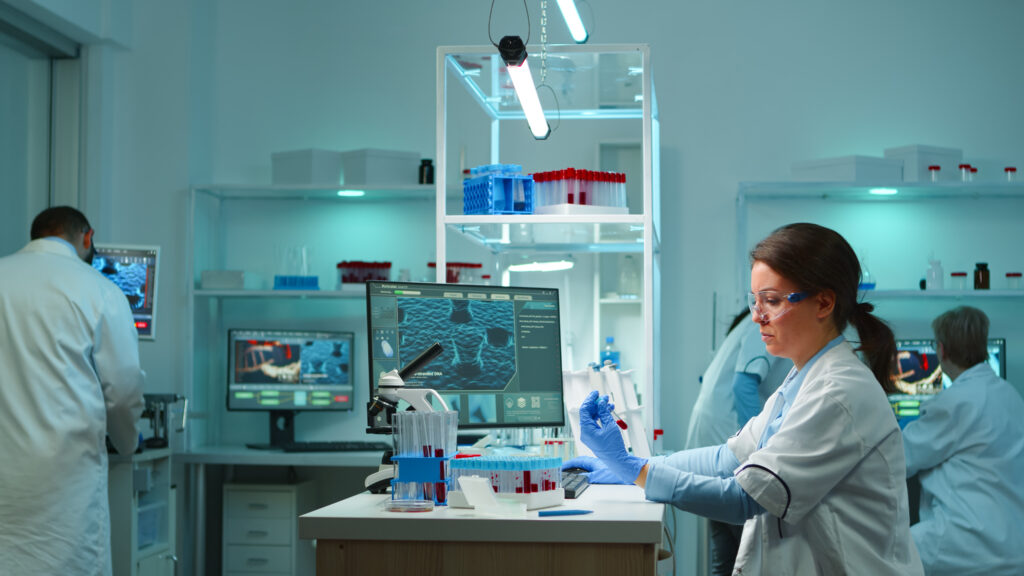 Scientists working in a modern laboratory using AI-assisted systems to analyze experimental data and support scientific research.