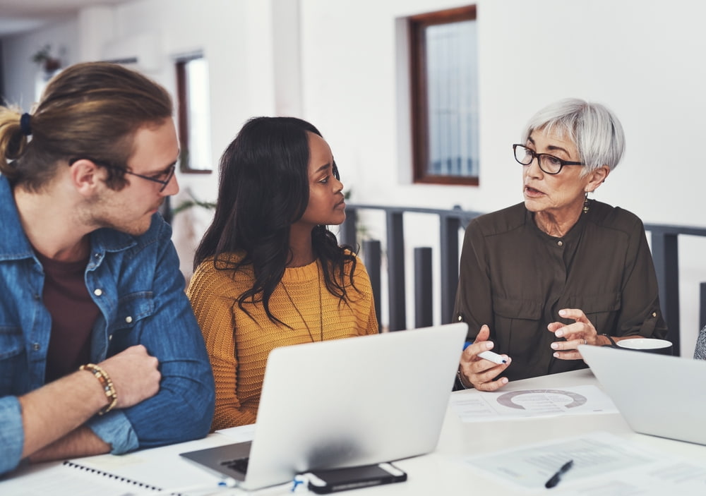 documents and business people with tech in meeting for company