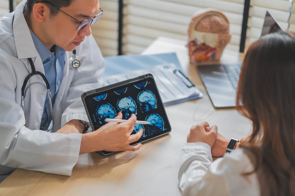 Doctor explaining brain skull MRI scan on tablet