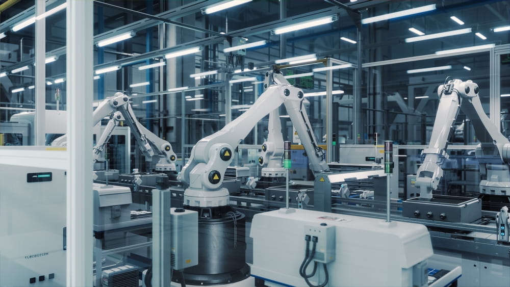 Tech Factory with White Robotic Arms Assembling Electronic Components